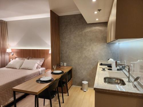 a room with a bed and a kitchen with a sink at Fabuloso Blend Setor Marista in Goiânia