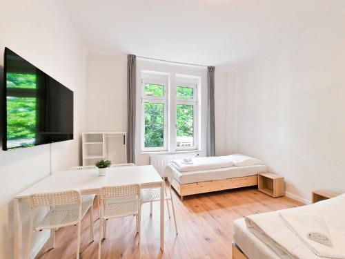 ein weißes Zimmer mit einem Bett, einem Tisch und Stühlen in der Unterkunft RAJ Living - 3 and 4 Room Apartments in Duisburg