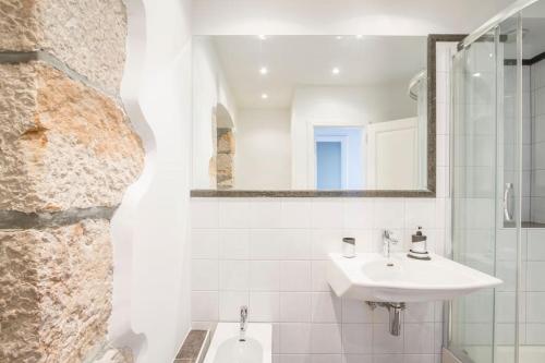 a white bathroom with a sink and a mirror at Villa Veli Palac in Baška