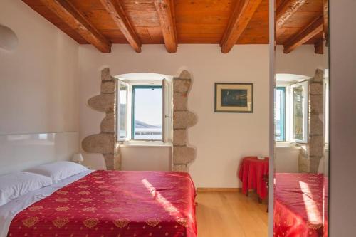 a bedroom with a bed with a red blanket at Villa Veli Palac in Baška