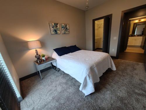 a bedroom with a bed and a table with a lamp at 520 Neil Luxury 2 Bedroom in Champaign