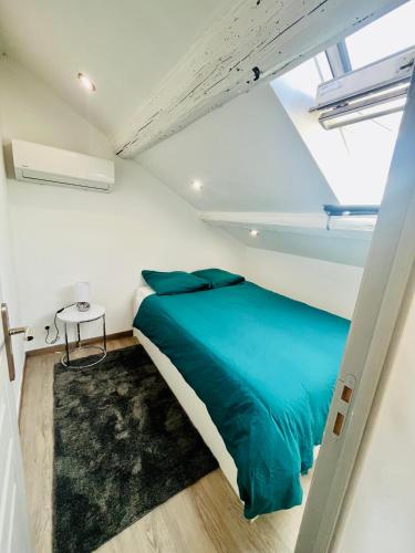 une chambre avec un lit bleu dans une pièce blanche dans l'établissement SUPERBE DUPLEX DESIGN NEUF 2 CHAMBRES, CLIMATISE TOUT CONFORT, FACILE D,ACCES STATIONNEMENT GRATUIT, à Marseille