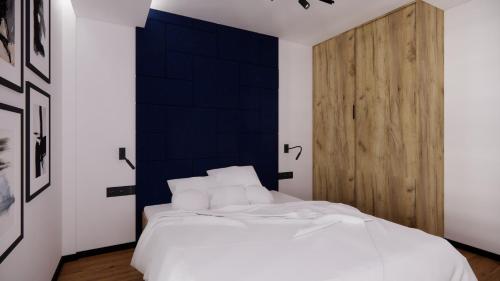 a bedroom with a white bed and a wooden door at RestPark in Kielce