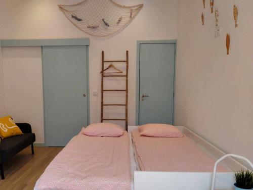 2 Betten in einem Zimmer mit rosa Bettwäsche in der Unterkunft Maria Sardinha_As Três Marias in Matosinhos
