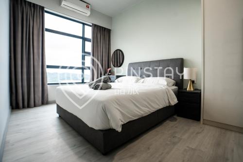 a bedroom with a large bed and a large window at Jesselton Quay by Pinstay in Kota Kinabalu