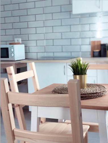 a wooden table with two chairs and a plant on it at Isamena in Las Playas