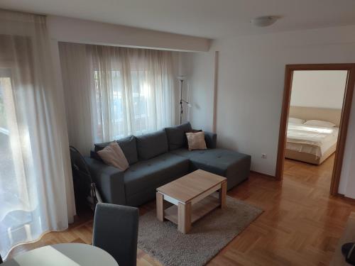 a living room with a blue couch and a table at Apartman Tedi in Zlatibor