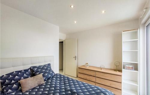 ein Schlafzimmer mit einem blauen Bett und einer Kommode in der Unterkunft Amazing Home In Lingolsheim With Wifi, Swimming Pool And 3 Bedrooms in Lingolsheim