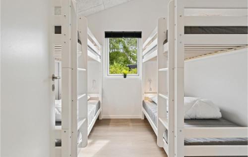 um quarto com beliches brancos e uma janela em 4 Bedroom Pet Friendly Home In Hadsund em Hadsund