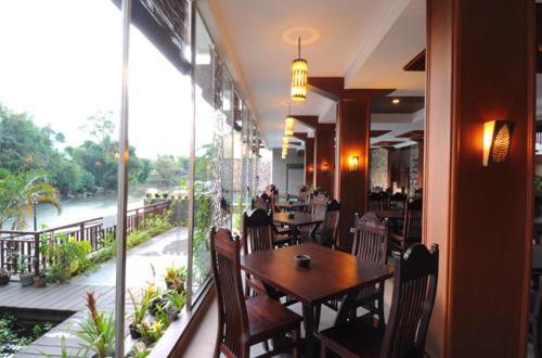 um restaurante com mesas e cadeiras e uma grande janela em Luta Resort Toraja em Rantepao