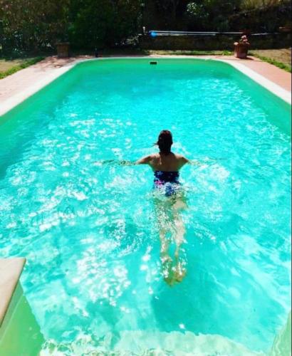 a man is in a swimming pool at B&B Il Casale Del Ginepro in Migliano