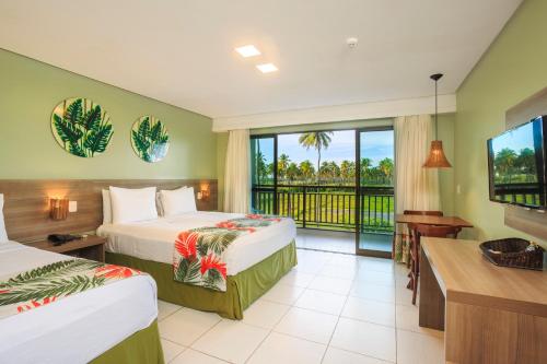 a hotel room with two beds and a balcony at Vivá Porto de Galinhas Resort in Porto De Galinhas