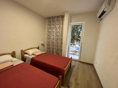 two beds in a room with a window at SeaAdrik in Bar