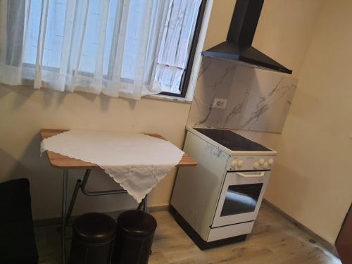 Il comprend une petite cuisine équipée d'une cuisinière et d'une table. dans l'établissement Rent House Pogradec, à Pogradec