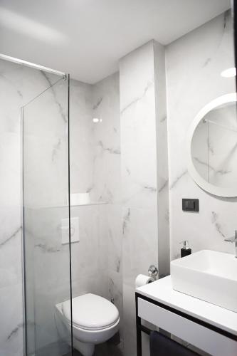a white bathroom with a toilet and a sink at Elite estate in Podstrana