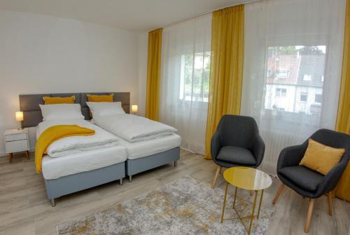 1 dormitorio con 1 cama, 2 sillas y ventana en Appartement mit Balkon Westfalenhalle und Universität fußläufig, en Dortmund