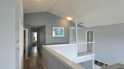 um corredor de uma casa com paredes brancas e uma escada em West-Haven-537 em Davenport