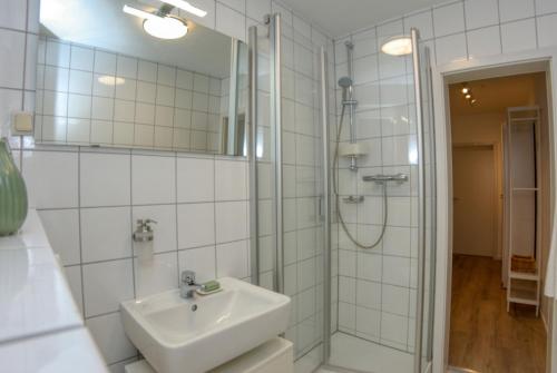 a white bathroom with a sink and a shower at Appartement mit Balkon Westfalenhalle und Universität fußläufig in Dortmund