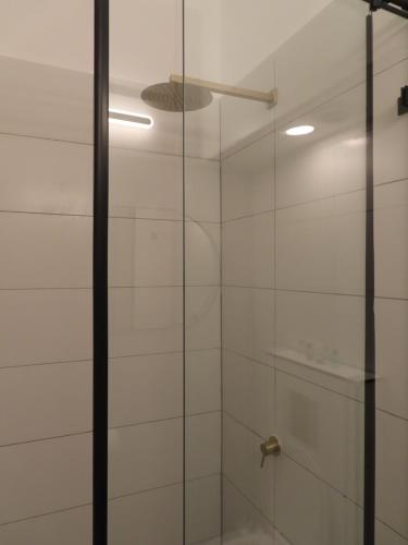 La salle de bains est pourvue d'une douche avec une porte en verre. dans l'établissement White Moon Inn, à Jérusalem