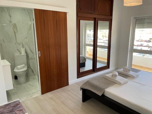 łazienka z łóżkiem, prysznicem i toaletą w obiekcie A Minha Praia w mieście Quarteira