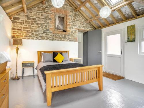 a bedroom with a bed and a brick wall at The Studio - Uk44779 in Hoel-galed