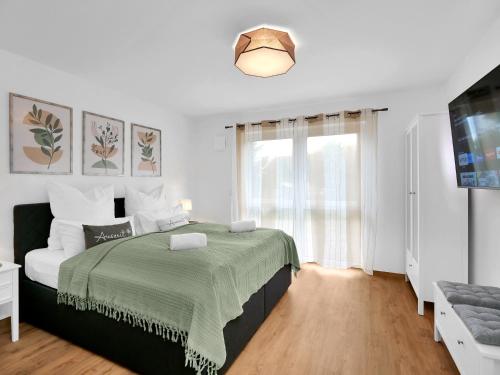 a white bedroom with a bed and a window at INhome 3x TV - Terrasse - Küche - Parken- Netflix in Crailsheim