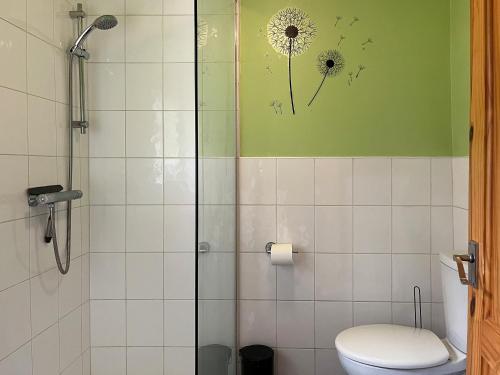 a bathroom with a shower with a toilet and a dandelion wall at Regent House in Leek