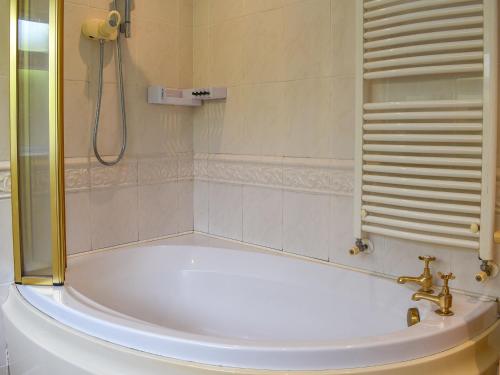 a white bath tub in a bathroom with a shower at Waterside Cottage in Saltash