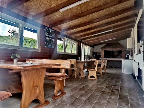 a kitchen with wooden tables and chairs and windows at Apartmani "Marina" in Otočac