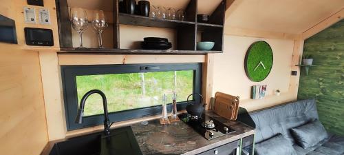 a kitchen with a sink and a window in a caravan at Tiny House Rákosníček in Malšín