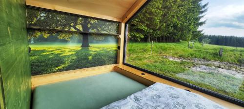 a room with a window with a view of a field at Tiny House Rákosníček in Malšín