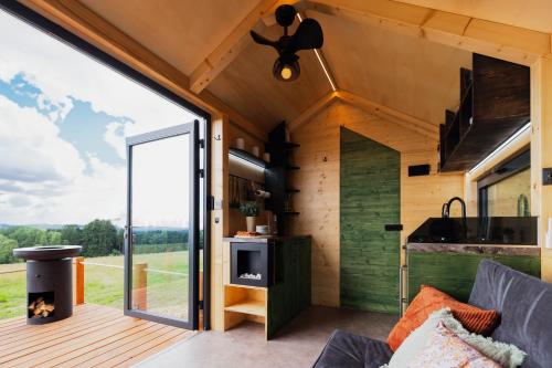an interior view of a tiny house with a large window at Tiny House Rákosníček in Malšín