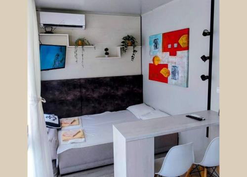 a small room with a bed and a desk at Къмпинг за Каравани и Кемпери Барите - Caravan Pitch Park Barite in Varna City