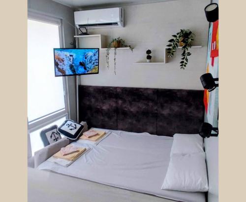 a bedroom with a white bed and a window at Къмпинг за Каравани и Кемпери Барите - Caravan Pitch Park Barite in Varna City
