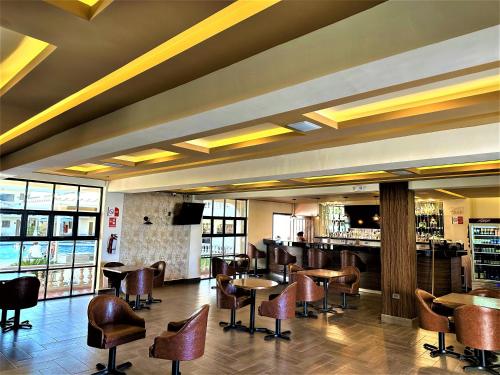 a restaurant with tables and chairs and a bar at KAVIA MEOQUI HOTEL & SUITES in Meoqui