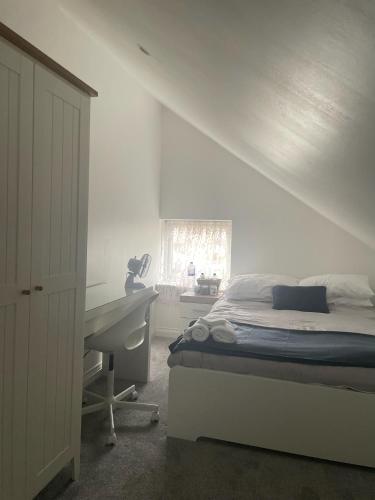 een slaapkamer met een bed, een bureau en een raam bij Cosy Double Room at The Whitley House in Shinfield