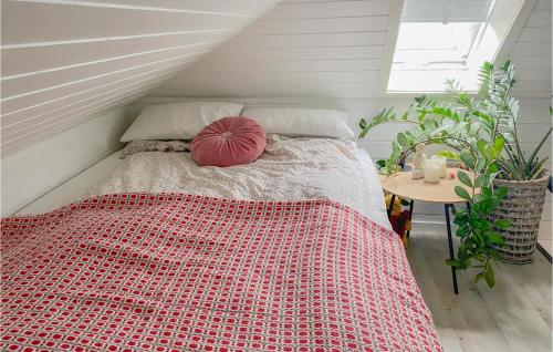 um quarto com uma cama com um edredão vermelho e uma mesa em Gorgeous Apartment In lesund With House A Panoramic View em Ålesund
