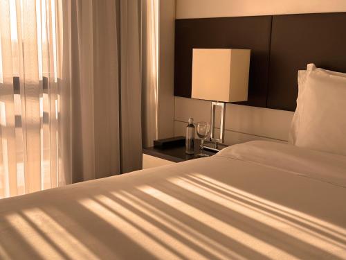 a bedroom with a bed and a lamp and a window at Kubitschek Plaza Hotel in Brasilia