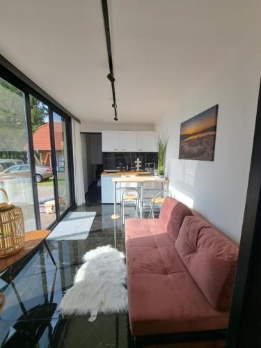 a living room with a couch and a table at HM - Tinyhouse 1 Deluxe Krombachtalsperre Westerwald in Driedorf