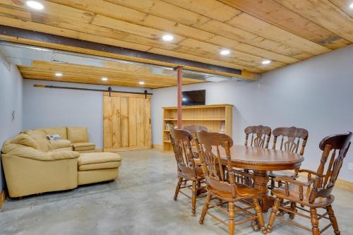 a dining room with a table and chairs and a couch at A-Frame Log Home with Game Room Near Lake George! in Bolton