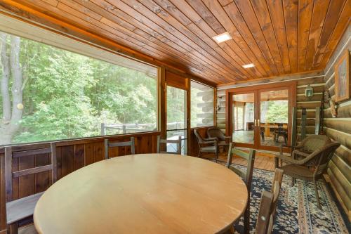 a dining room with a table and a large window at A-Frame Log Home with Game Room Near Lake George! in Bolton