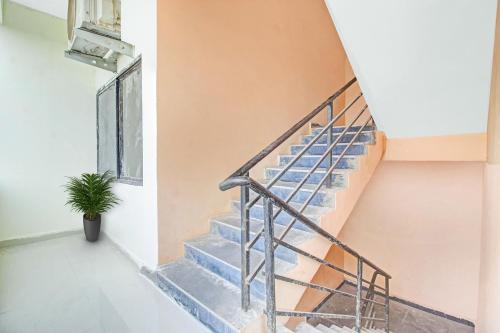 a staircase in a house with a potted plant at Capital O Ragas Inn in Hyderabad