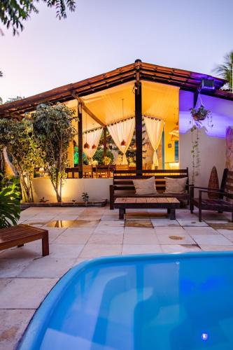 a house with a swimming pool and a patio at Pousada Carioca - Pousada de Charme in Jericoacoara