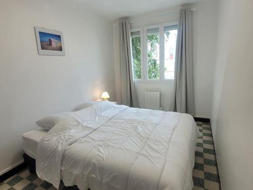 - un lit blanc dans une chambre avec fenêtre dans l'établissement Appartement familial terrasse vue mer avec parking, à Berck-sur-Mer