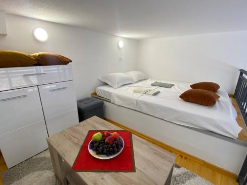 Una habitación con una cama y un bol de fruta en una mesa en Sutorange, en Sutomore