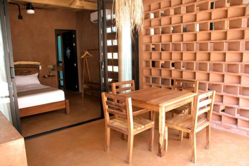 a room with a table and chairs and a bed at Punta Navi - Adults only - Boutique hotel in Puerto Escondido