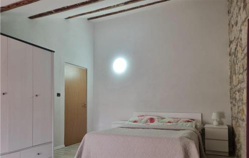 een witte slaapkamer met een bed met roze lakens bij Nice Apartment In Funtana With Kitchen in Funtana
