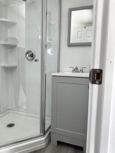 a white bathroom with a shower and a sink at Tiny house in the heart of MOVAL private freeparking Netflix in Moreno Valley