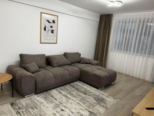 a living room with a brown couch and a table at Traian Taranu Apartment in Suceava