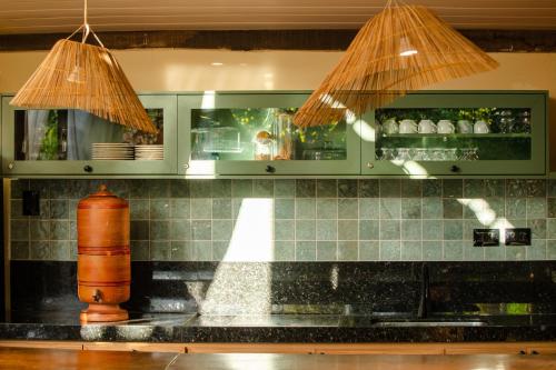 a kitchen with a counter with two lights above a sink at Pousada Carioca - Pousada de Charme in Jericoacoara